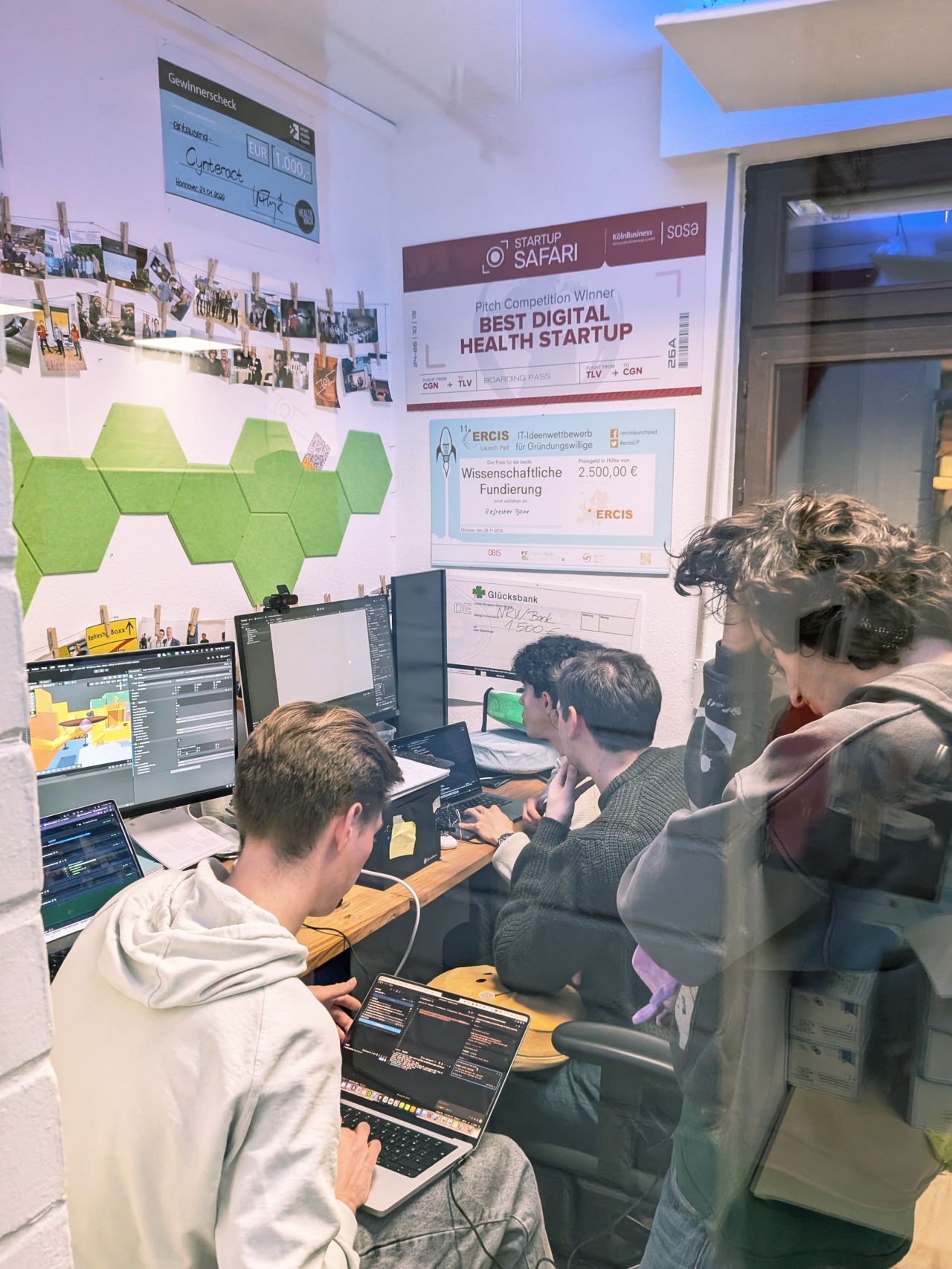 The team working at computers during the game jam, with the Unity editor visible on screen