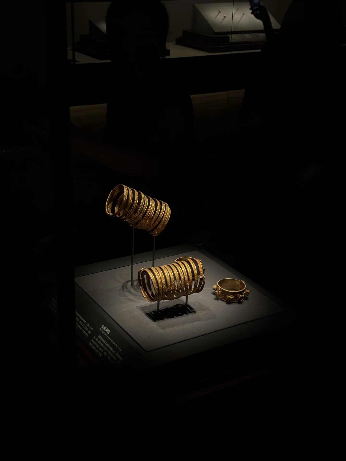 Gold bracelets displayed in a dark museum case