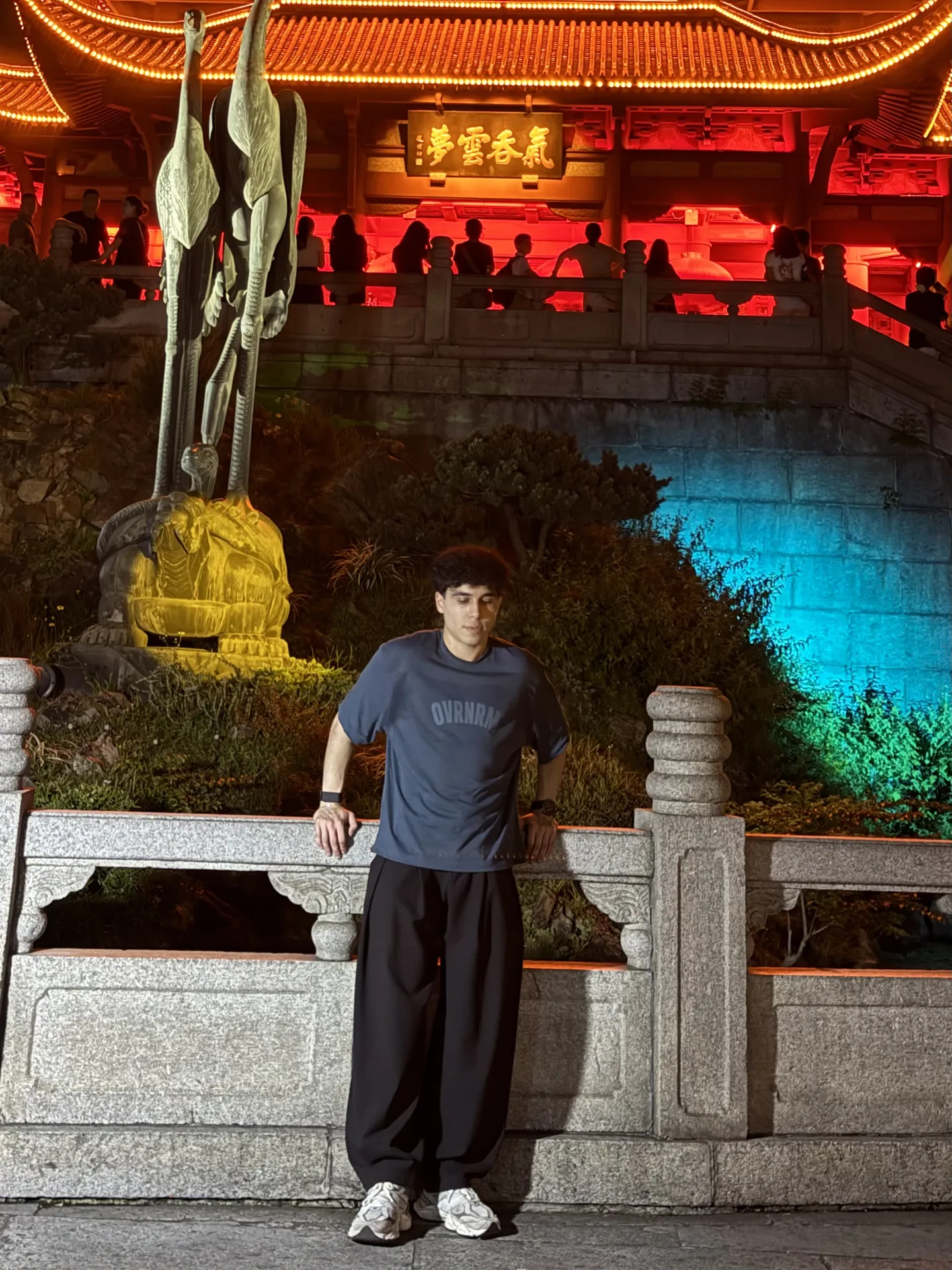 Me standing in front of the lit up Yellow Crane Tower at night